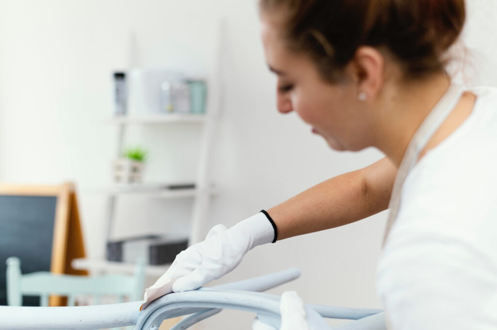 Person reinigt ein Möbelstück sorgfältig mit Handschuhen.